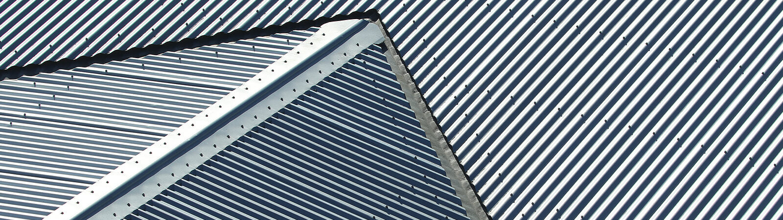 Close up of metal roofs joining at centre of roof